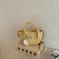 Vintage yellow bucket shoulder bag with elegant pearl flower bow charm on a stone block. - With Pendant / Yellow with Pendant
