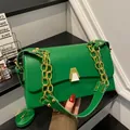 Close-up of a stylish green rectangular shoulder bag with chunky gold chain strap - Green