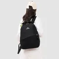 Back view of a large-capacity black sports backpack worn by a model in casual wear - Obsidian Black