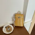 Vue détaillée du sac à bandoulière jaune minimaliste avec un charmant pendentif étoile - Avec Pendentif / Jaune