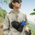 Outdoor lifestyle detail of a black hiking crossbody bag with water bottle compartment - Black
