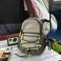 Detailed view of a lightweight hiking backpack with bungee cords in a camping scene - Khaki