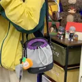 Detail van de lichte crossbody telefoontas met trekkoord en kleurvlakken - Met Charm / Zwart