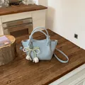 Detail of light blue bucket bag with a pearl bow tulip charm on a rustic wooden table - With Pendant / Blue with Charm