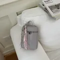 Détail mini sac bandoulière gris avec breloque étoile et rubans sur canapé. - Avec Pendentif / Violet