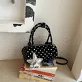 Close-up of a stylish black cylinder handbag with white polka dots and star charm - With Pendant / Black