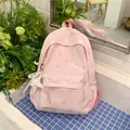 Macro view of pink floral school backpack with star charm in a fresh garden setting - With Charm / Pink
