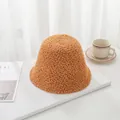 Detailed view of a warm brown lambswool bucket hat on a minimalist white table setting. - 55-58cm / Camel
