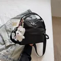 Detail of black plaid crossbody bag with a cute white dog plush charm - With Charm / Black