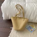 Detailed macro shot of a stylish yellow woven shoulder tote bag for summer fashion - Yellow