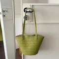 Detail view of a stylish green woven shoulder tote bag with elegant scalloped edges - Green