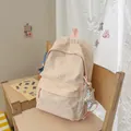 Close-up of a stylish pink backpack with star patterns and a star plush charm on a chair - With Charm / Pink