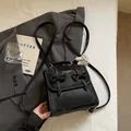 Primo piano dello zaino nero in pelle con fiocchi decorativi stile scolastico. - Stile Con Ciondolo / nero con ciondolo