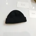Macro view of a black ribbed knit beanie showing texture and round crown design - 54-58cm / Black