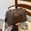 Modische braune strukturierte Handtasche mit PR-Logo und breitem Schultergurt. - Gewebte Textur / Braun