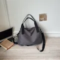 Vista dettagliata della borsa da viaggio a scacchi grigi in un ambiente ufficio. - Grigio