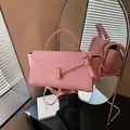 Close-up of pink crossbody handbag with gold clasp and mirror reflection - Pink