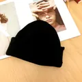 Nahaufnahme einer stylischen schwarzen Strickmütze auf einem Modemagazin-Hintergrund - Universalgröße / Schwarz