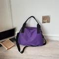 Vista dettagliata della borsa da viaggio viola a scacchi in un ambiente interno moderno - Viola
