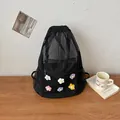 Lifestyle view of black mesh backpack with colorful knit flowers - Black