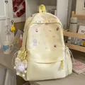 Close-up of sweet aesthetic yellow backpack featuring cute cartoon prints and plush charm - With Charm Style / Yellow