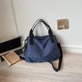 Grande borsa da viaggio a scacchi blu su una scrivania con laptop e libro in dettaglio - Blu