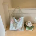 Detailed view of a Chinese style shoulder bag with pink floral embroidery and lace layer. - Green