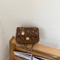 Vintage bruine gewatteerde schoudertas met gouden ketting op houten rek - Bruin