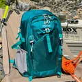 Outdoor detail of a turquoise waterproof hiking backpack with gear in camping setting - Lake Blue