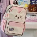 Detailed view of cute cat-themed backpack in pink and cream with a rabbit plush pendant - Pink