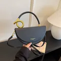 Detailansicht der schwarzen halbmondförmigen Umhängetasche mit elegantem Goldgriff - Schwarz