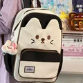 Close-up of cute cat-themed black and white backpack with plush kitten pendant accessory - Black