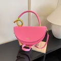 Stylish pink saddle bag featuring a unique decorative gold hardware knot on the handle. - Rose Pink