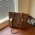 Large brown textured tote bag with elegant flower charm detail for women's daily commute - With Charm / Coffee