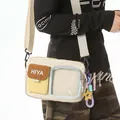 Close-up of a sporty crossbody bag with clear pocket and decorative star charm - With Charm / White