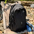 Wanderrucksack in einer realistischen Outdoor-Camping-Umgebung mit Ausrüstung - Schwarz