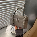 Close-up detail of gray textured mini box bag with silver double zippers and top handle - Gray