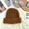 Close-up detail of a thick brown chunky knit beanie hat on a cozy fabric background. - 55-62cm (Elastic) / New Oversized Knit Hat (AC8924) / Coffee