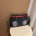Unique denim shoulder bag featuring a creative red belt skirt design and pockets. - Black