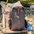 Sac à dos de randonnée gris et orange posé sur une chaise de camping en plein air - Gris Foncé Fantôme