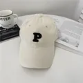 Minimalist beige cotton baseball cap featuring a black embroidered P letter on the front - 58-65cm (Adjustable) / Off White