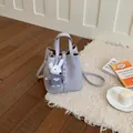 Sac seau minimaliste en cuir lavande avec un adorable porte-clés lapin blanc sur un tapis - Violet Avec Pendentif