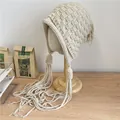 Handgestrickte, grobe beige Beanie mit langen dekorativen Quasten und Ohrenklappen - 56-60cm / Beige