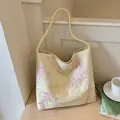 Elegant pale yellow bucket bag with pink floral embroidery and braided strap detail - Yellow