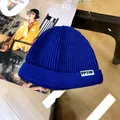 Detailed close-up of a blue ribbed knit beanie for children featuring a white PPSW label - 3 Years+ to Adult / Sapphire Blue