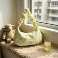 Yellow floral printed hobo bag with ruffled handle displayed on a sunlit windowsill with toys - Yellow Floral Puppy / Yellow