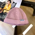 Detailed macro shot of a stylish pink children's knitted beanie featuring a PPSW letter tag. - 3 Years+ to Adult / Pink