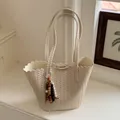 Beige woven bucket bag with scalloped edges and beaded tassel charm - With Pendant / Off White