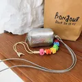 Detailed view of silver metallic mini square bag featuring a colorful smile letter bead strap - Silver