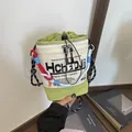 Detail einer lässigen Canvas-Beuteltasche mit buntem geflochtenem Seilriemen und Grafiken - Grün